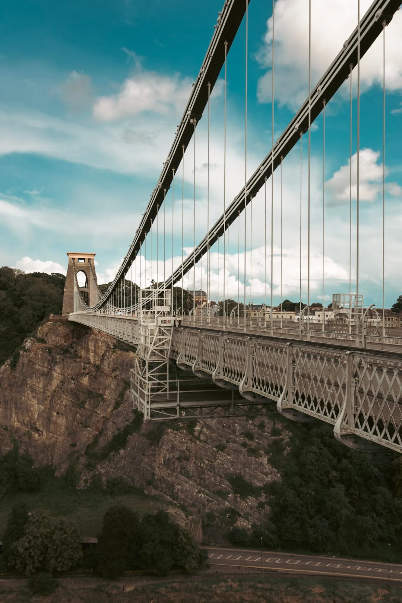 The Clifton Suspension Bridge from above the gorge, its deck and cables running away to the far tower, with the cliffs below